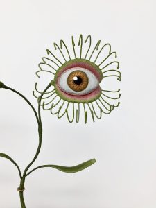 an embroidered sculpture of a venus fly trap, but with an eye where the fly trap would be