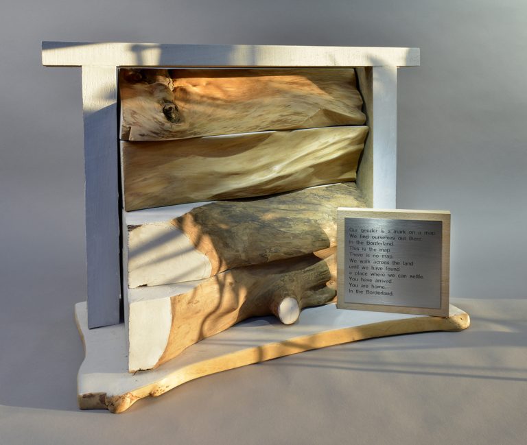 Four 7.5cm thick slices of naturally textured and waxed hardwood timber set within a painted frame and base, like layers of rock within a proscenium arch.There is also a separate wood block on which is a metal plate with etched words.