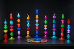 PLAY_ZONE (2018) An interactive glass installation that can played like an instrument. The colours on a round console are assigned to the colours in the 9 sourronding modular lamps as well as a specific (digitally generated) sounds. It requires audience participation.