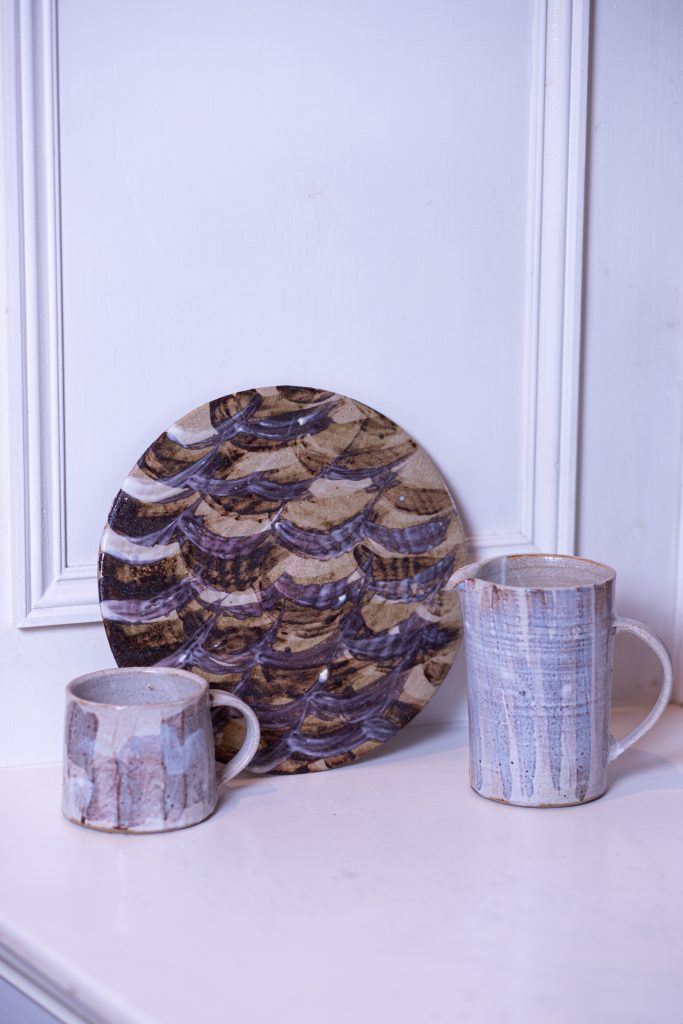 Wheel thrown mug and jug which have a wild clay slip on the surface, the clay used was collected from the river Kelvin in Glasgow and Ayr. In the middle, a decorative disk with expressive markings.