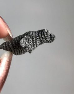 A tiny sculpture of a grey seal is held between my finger tips. The seal is 4cm long and is crafted from fine cotton sewing thread. This piece forms part of a series of micro-mammals, in which I freehand crocheted one UK mammal a day for seven days.