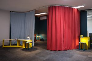 A quiet room, with a dark space partitioned off with blue and red curtains.