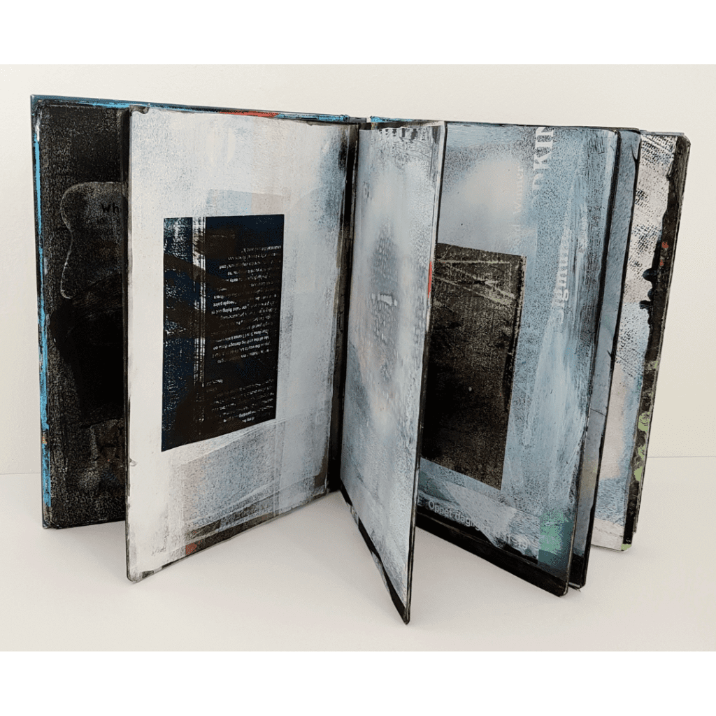 A book stood upright and open so you can see the pages. They are painted or collaged.