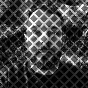 Back and white portrait of a white man's head and shoulders, overlaid with a diagonal grid-like pattern.