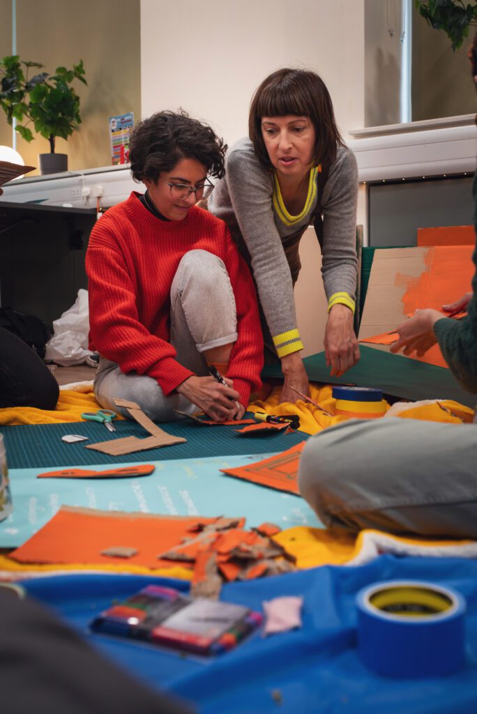 Two members working together on a piece of work on the floor.