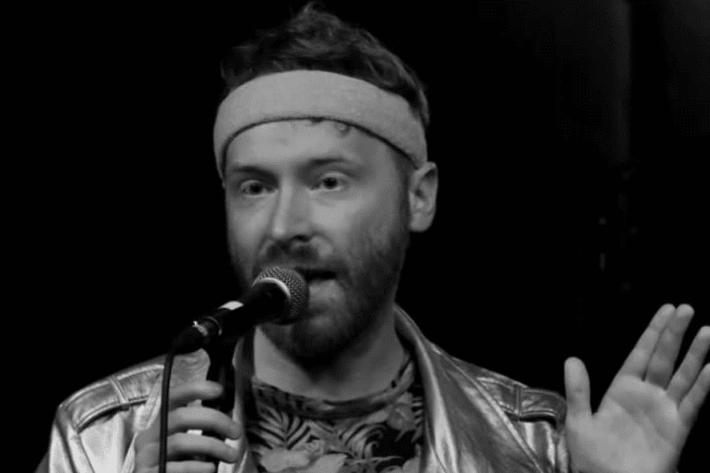 Black and white photo of a man singing into a microphone